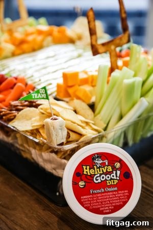 A creative football-themed snack stadium featuring an assortment of finger foods and dips, perfect for game day entertaining.