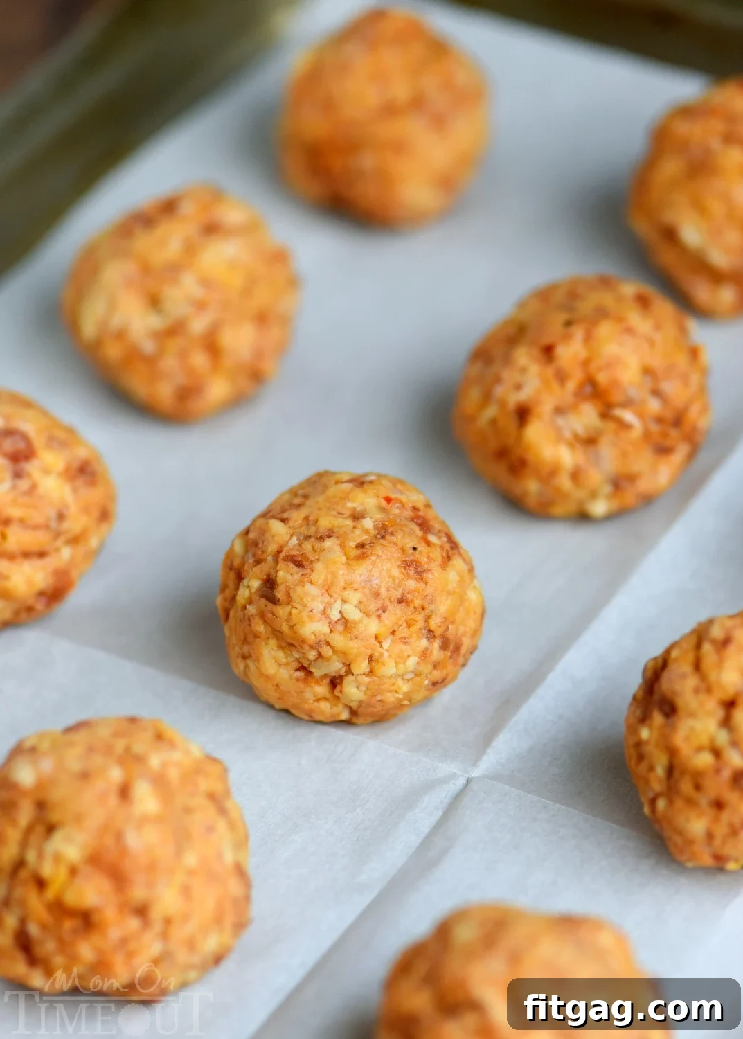Several sausage balls made with Bisquick and cheese, piled on a platter.