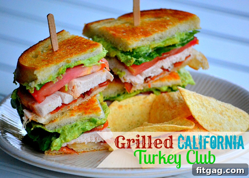 Two halves of a delicious Grilled California Turkey Club sandwich presented artfully on a wooden cutting board, with fresh herbs and a whole avocado visible in the background