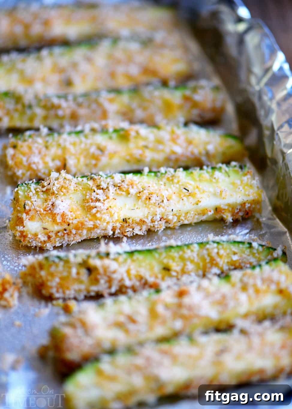 Crispy Baked Parmesan Zucchini Sticks 5 A plate of golden Baked Parmesan Zucchini Fries with a side of dipping sauce.