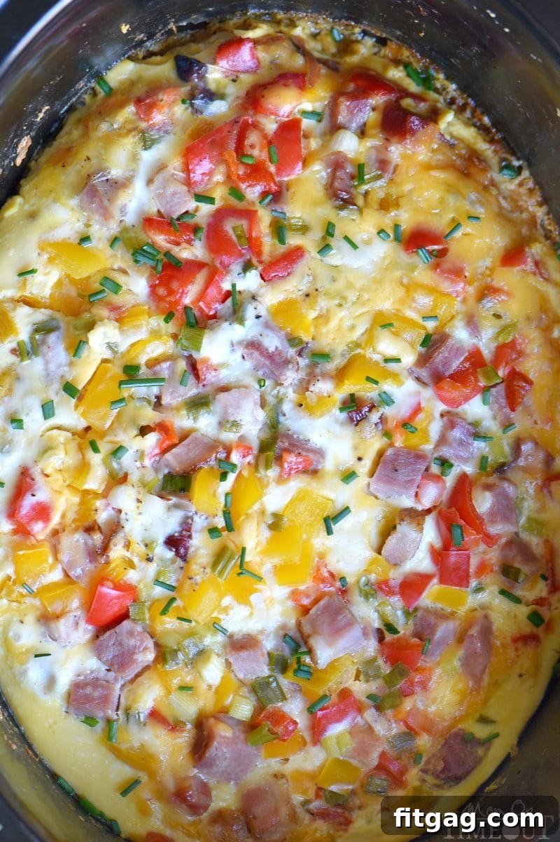 Hearty Ham and Cheese Overnight Slow Cooker Breakfast Casserole 3 A close-up shot of the cooked Slow Cooker Overnight Ham and Cheese Breakfast Casserole, showcasing the golden-brown top, melty cheese, and hearty ingredients. Ideal for a family breakfast.