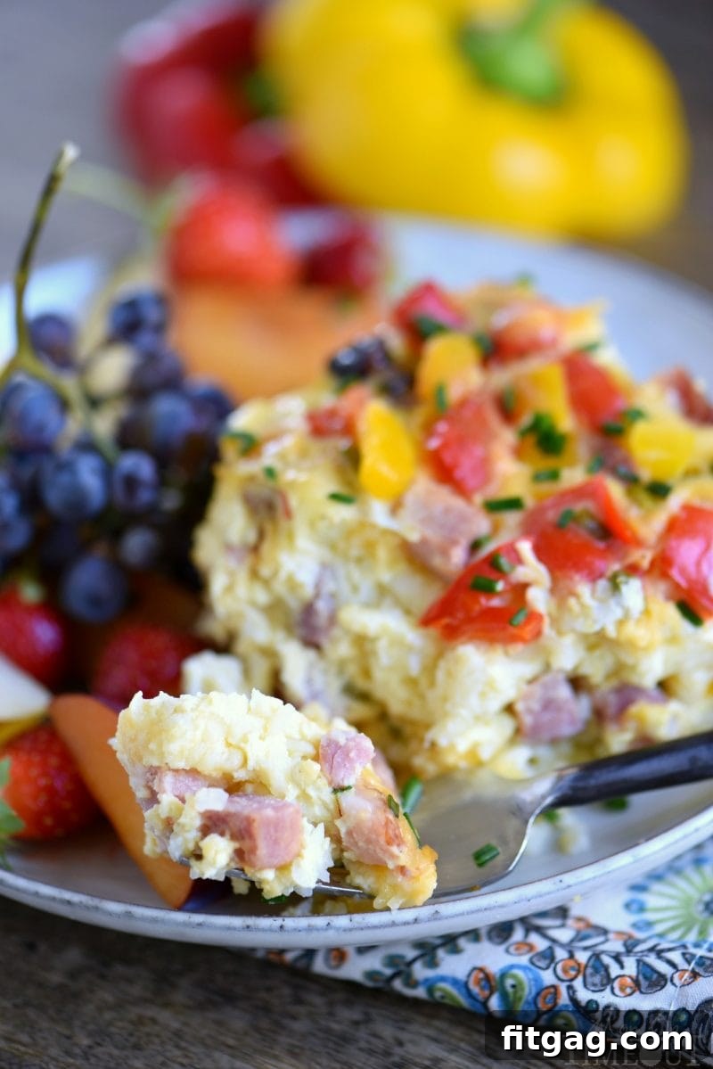 Hearty Ham and Cheese Overnight Slow Cooker Breakfast Casserole 5 A close-up of a serving of Slow Cooker Overnight Ham and Cheese Breakfast Casserole, highlighting its layered ingredients and golden-brown top. Perfect for individual portions.