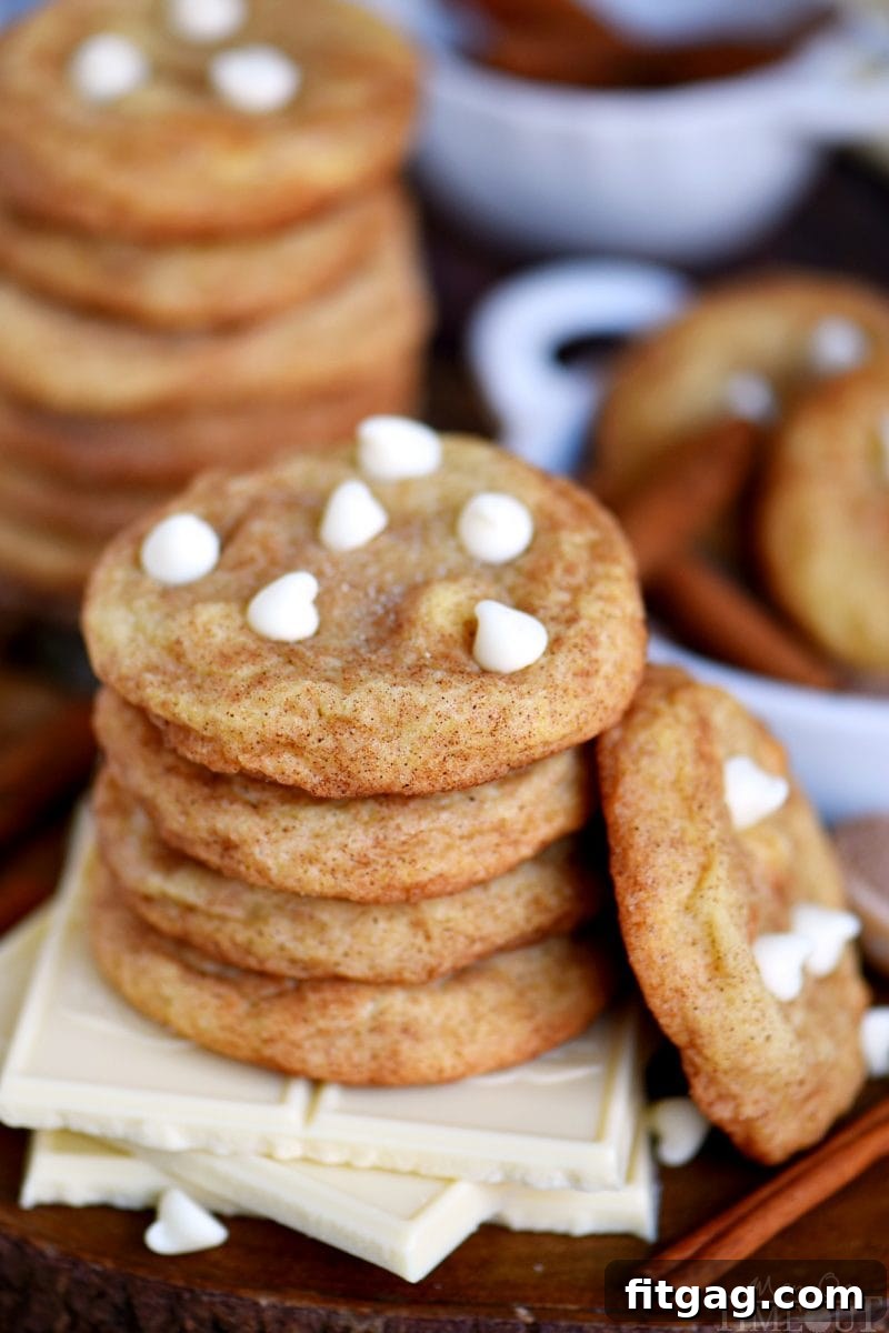 Chewy white chocolate snickerdoodles stacked on elegant white chocolate squares, tempting to pick up and enjoy.