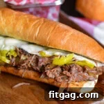 Italian Beef Sandwich sitting on wood cutting board with a basket of chips behind it.