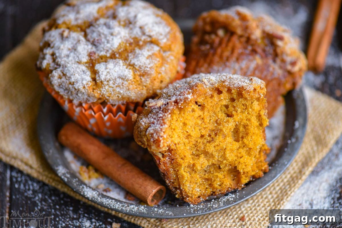 A wide shot featuring a bountiful display of pumpkin muffins arranged beautifully on a round metal plate, with a rustic cinnamon stick placed artfully to the side, enhancing the autumnal theme.