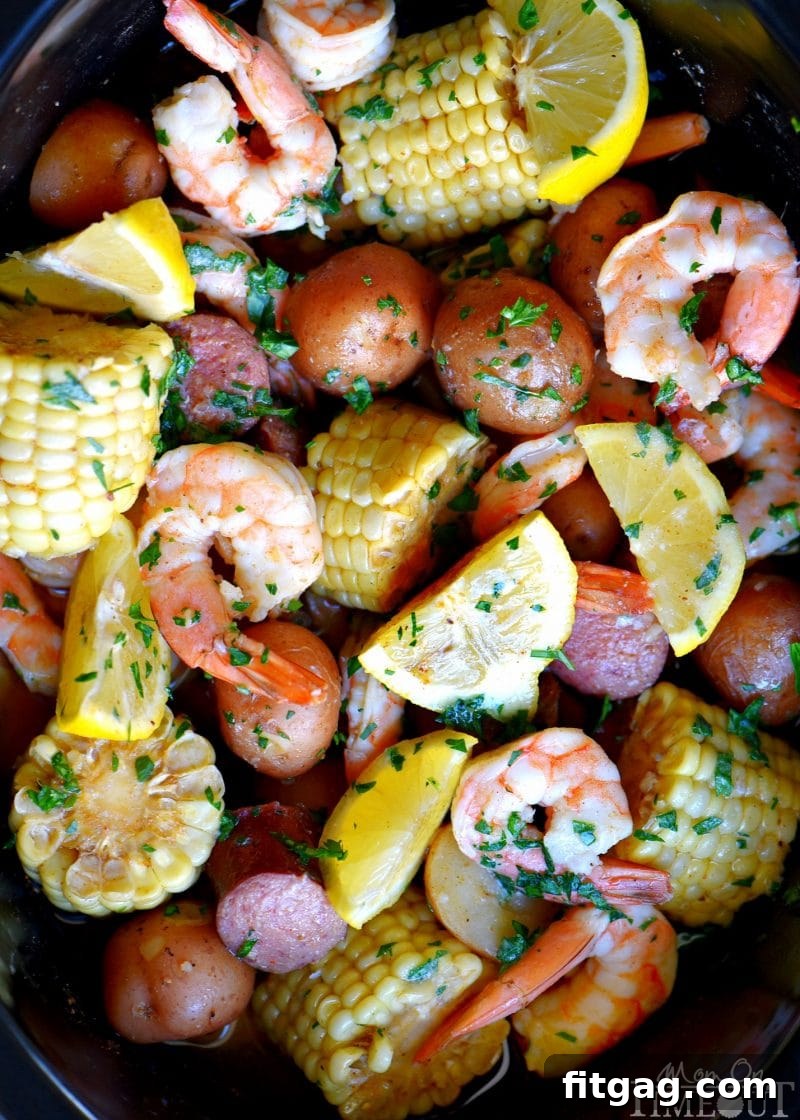 Slow Cooker Shrimp Boil cooking in a crockpot, showcasing tender potatoes, flavorful sausage, and sweet corn simmering together in a seasoned broth before the addition of shrimp.