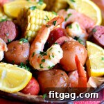 Top-down view of a delicious Slow Cooker Shrimp Boil in a serving dish, featuring perfectly cooked shrimp, potatoes, corn, and sausage, garnished with fresh lemon wedges.
