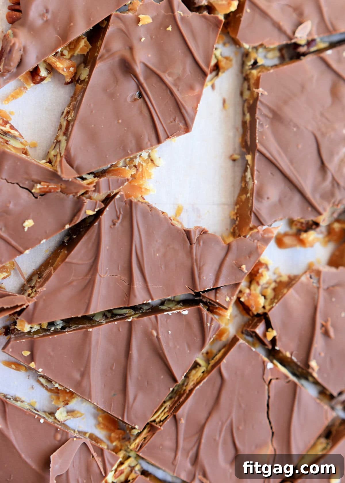 toffee candy broken up on a piece of parchment paper into smaller pieces.