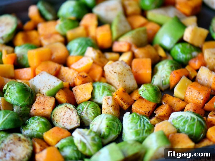 Oven Roasted Brussels Sprouts, butternut squash, and apples on a baking sheet before roasting spiced roasted brussels sprouts with squash and apples on a baking sheet