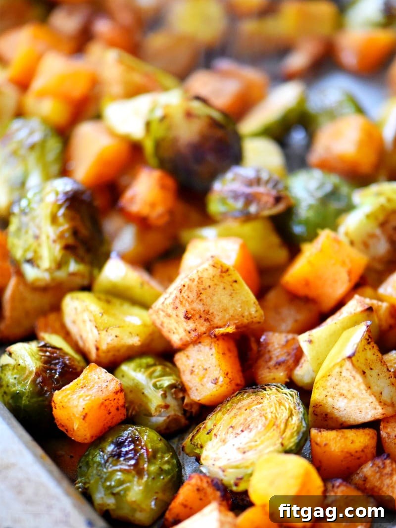 Golden brown oven roasted Brussels sprouts, butternut squash, and apples fresh from the oven oven roasted brussels sprouts on baking sheet, golden brown and caramelized