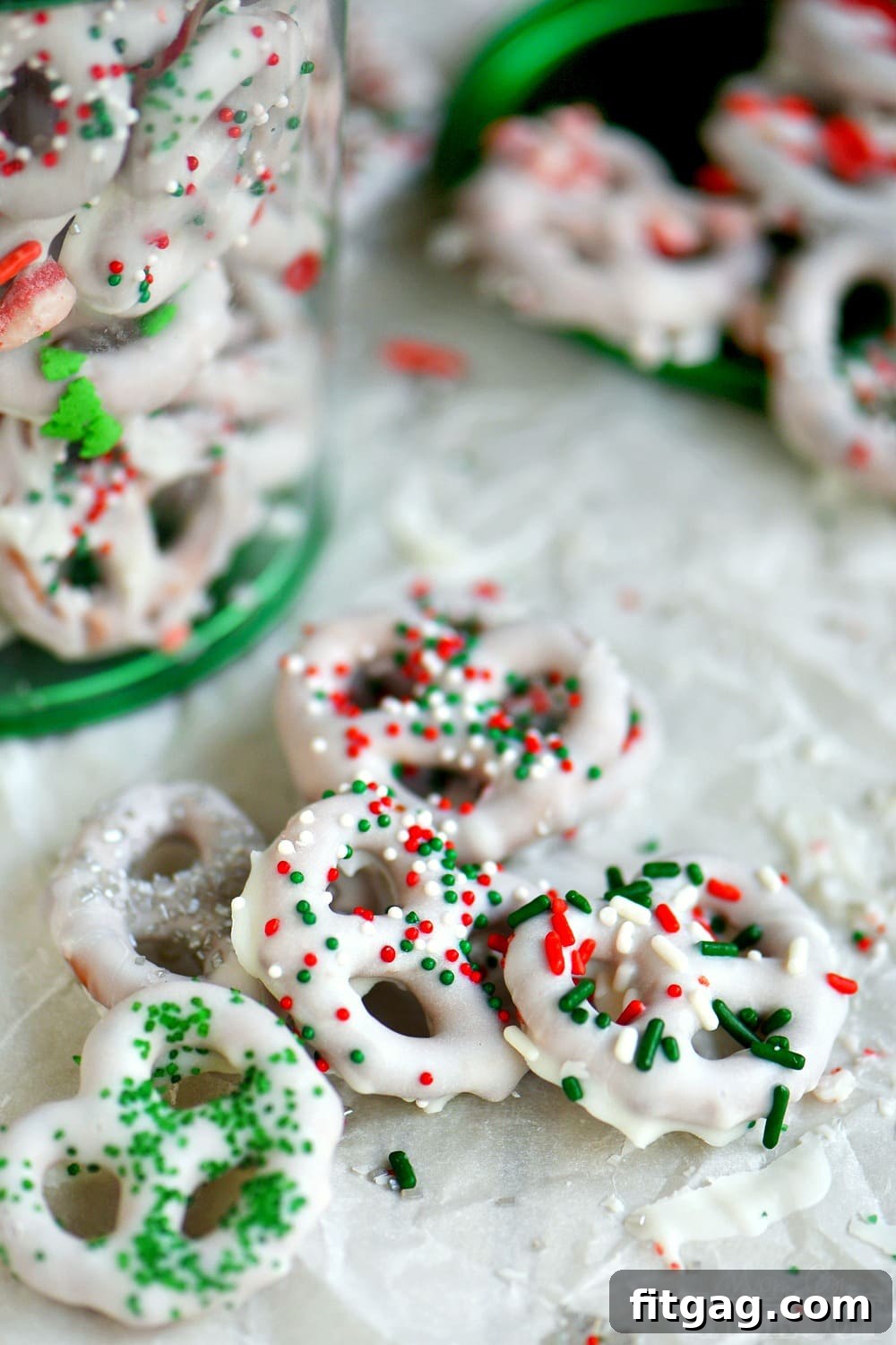 Simple White Chocolate Pretzel Delights 4 Close-up of a hand dipping a pretzel into melted white chocolate, demonstrating the easy dipping process for holiday treats.