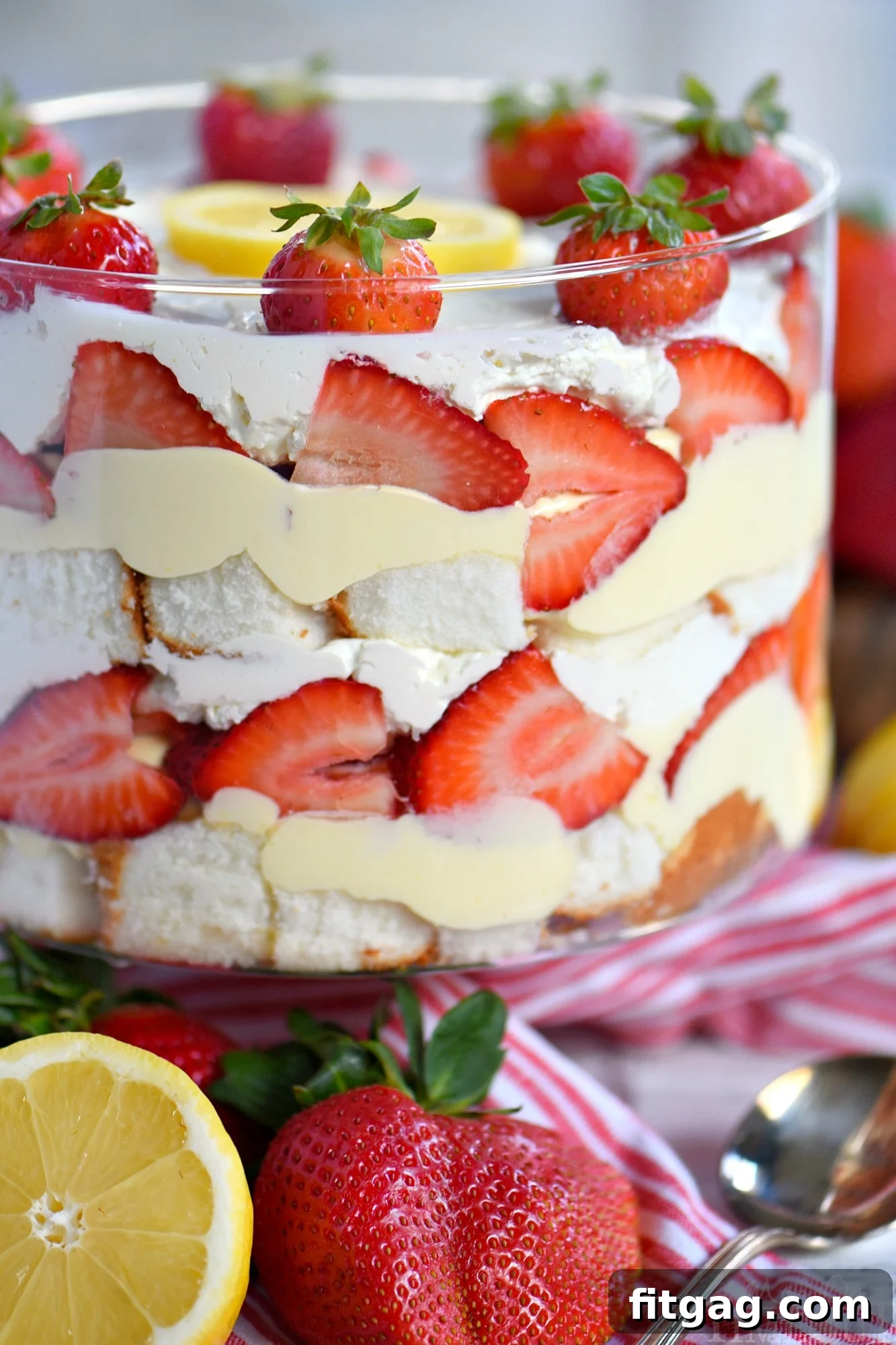 This Lemon Strawberry Trifle is what dreams are made of! An easy, no bake trifle recipe that is loaded with fresh strawberries, angel food cake, and lemon pudding - sure to be the highlight of your party! Perfect for easy entertaining during spring and summer! // Mom On Timeout #strawberry #lemon #trifle #dessert strawberry-lemon-trifle-dish
