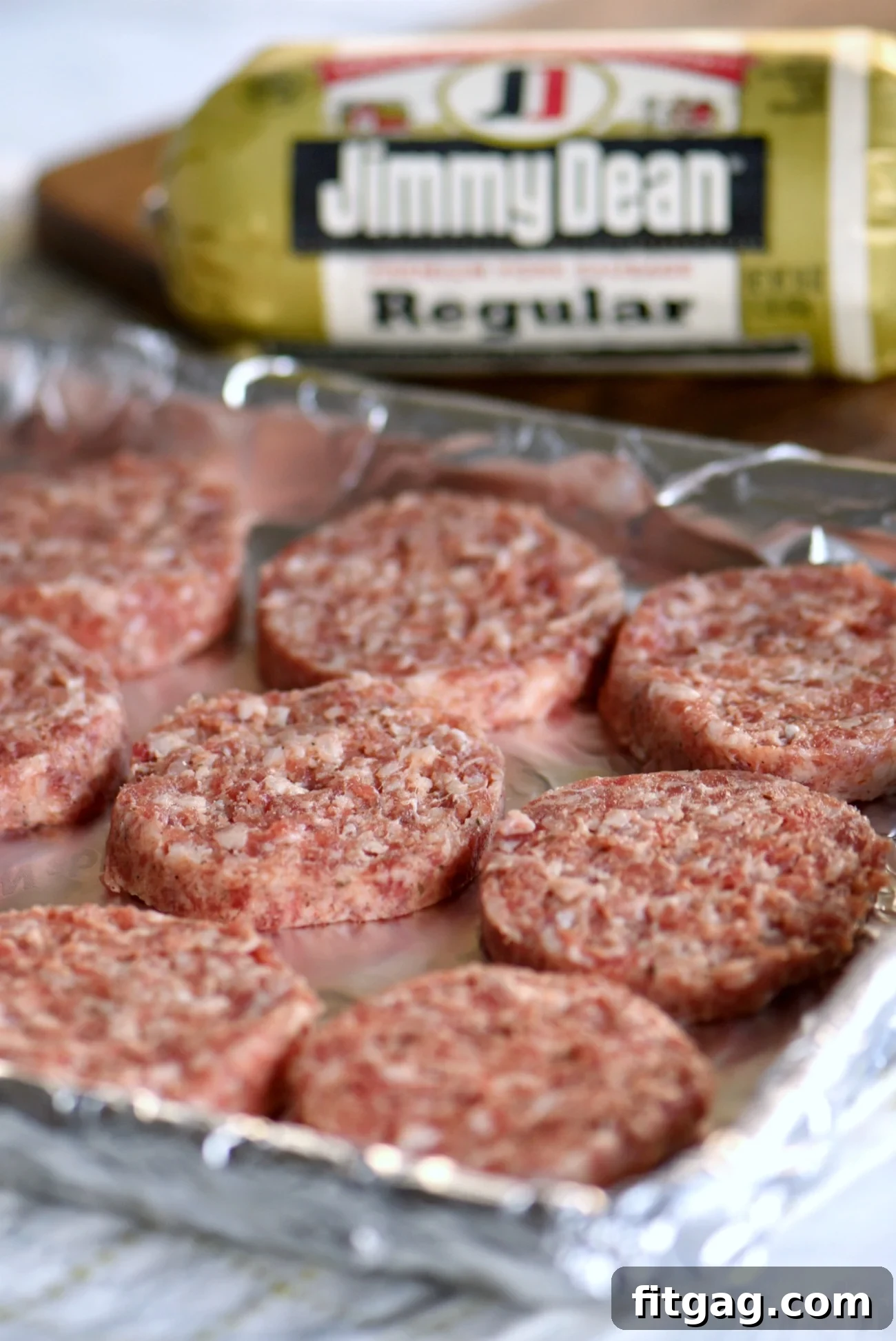 Jimmy Dean Premium Pork Sausage patties baking on a foil-lined sheet, a key ingredient for savory breakfast cups.