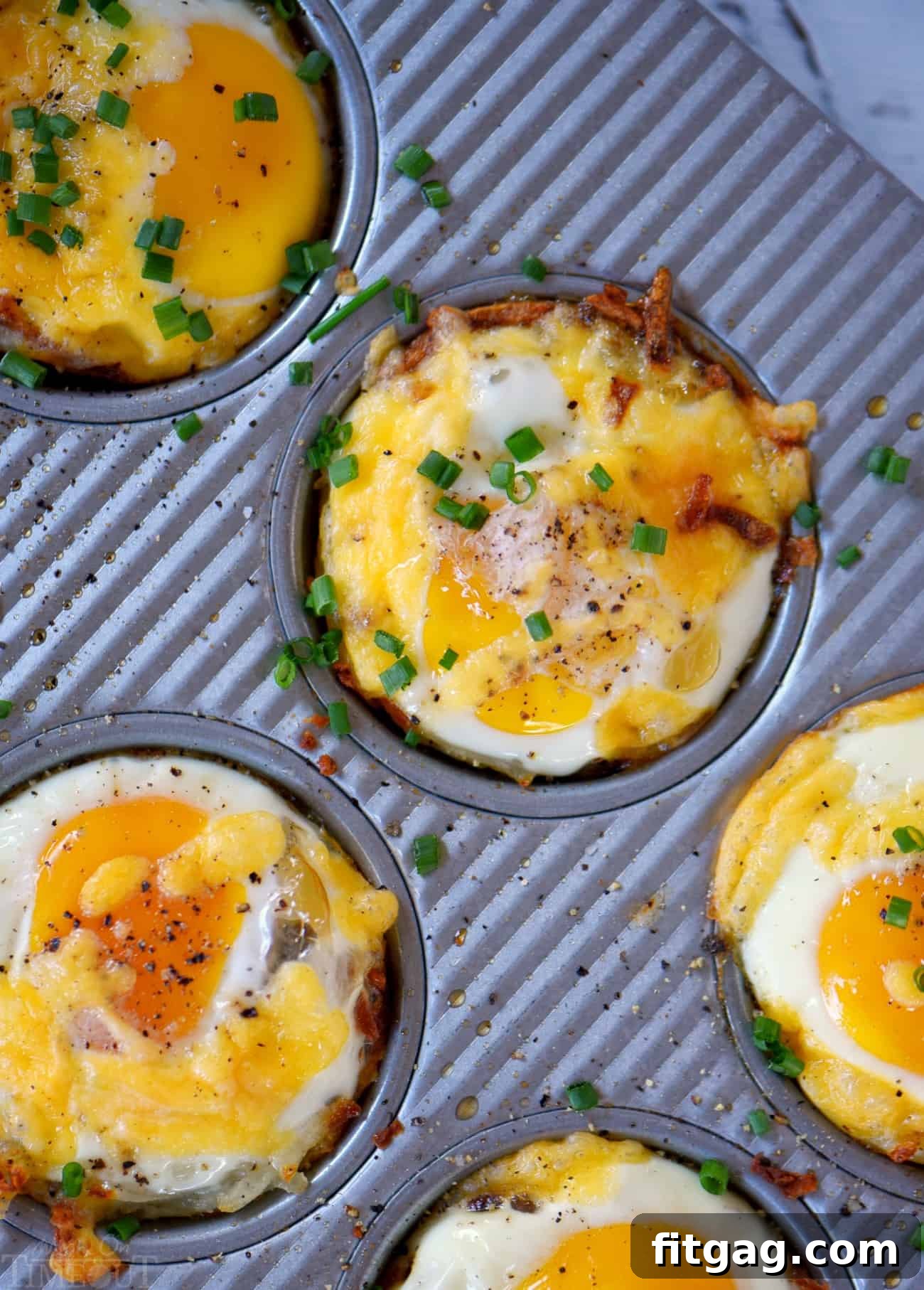 Baked Sausage and Egg Hash Brown Cups garnished with fresh chives, ready to serve.
