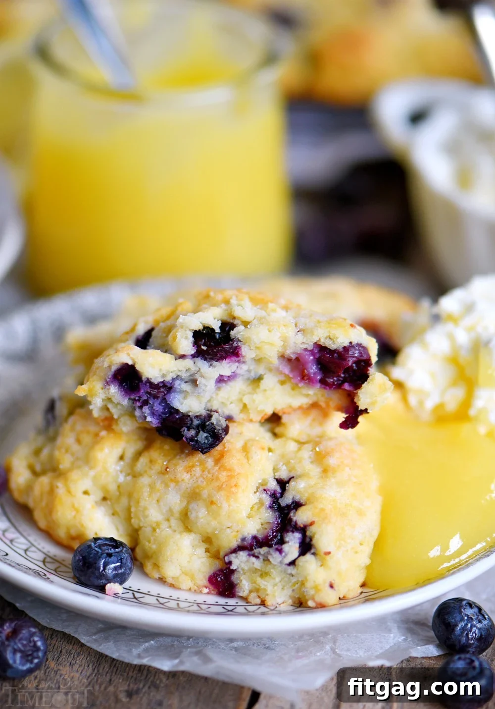 Close-up of a single blueberry scone beautifully garnished with lemon zest, highlighting its golden crust