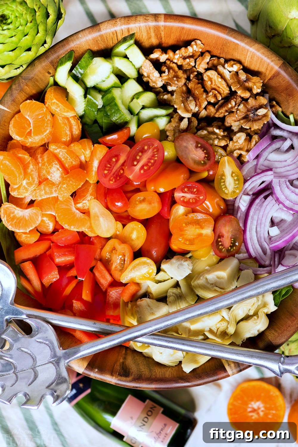All the fresh ingredients for Perfect Pasta Salad laid out: pasta, spinach, artichokes, mandarins, bell peppers, tomatoes, walnuts, and feta cheese.