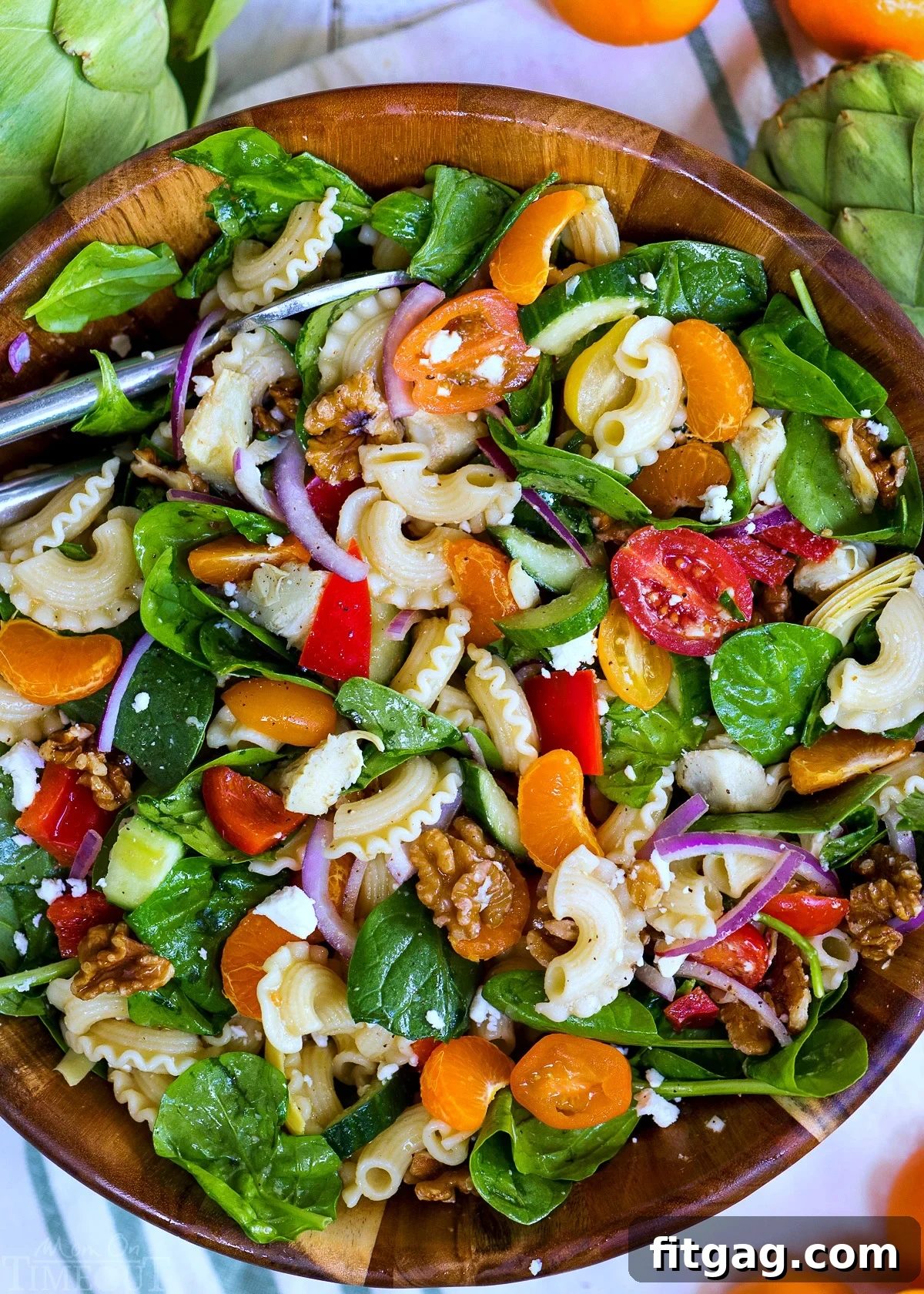 The finished Perfect Pasta Salad with artichokes, spinach, mandarins, and feta in a large bowl, ready to be served.