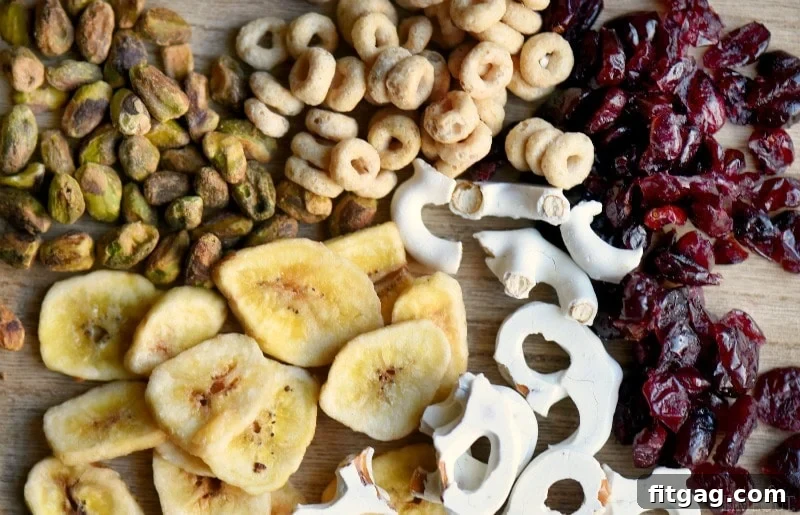 Close-up of a bowl of homemade Breakfast Trail Mix with pistachios, dried cranberries, banana chips, and yogurt-covered pretzels.