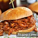 A mouthwatering BBQ pulled chicken sandwich on a green and white napkin.