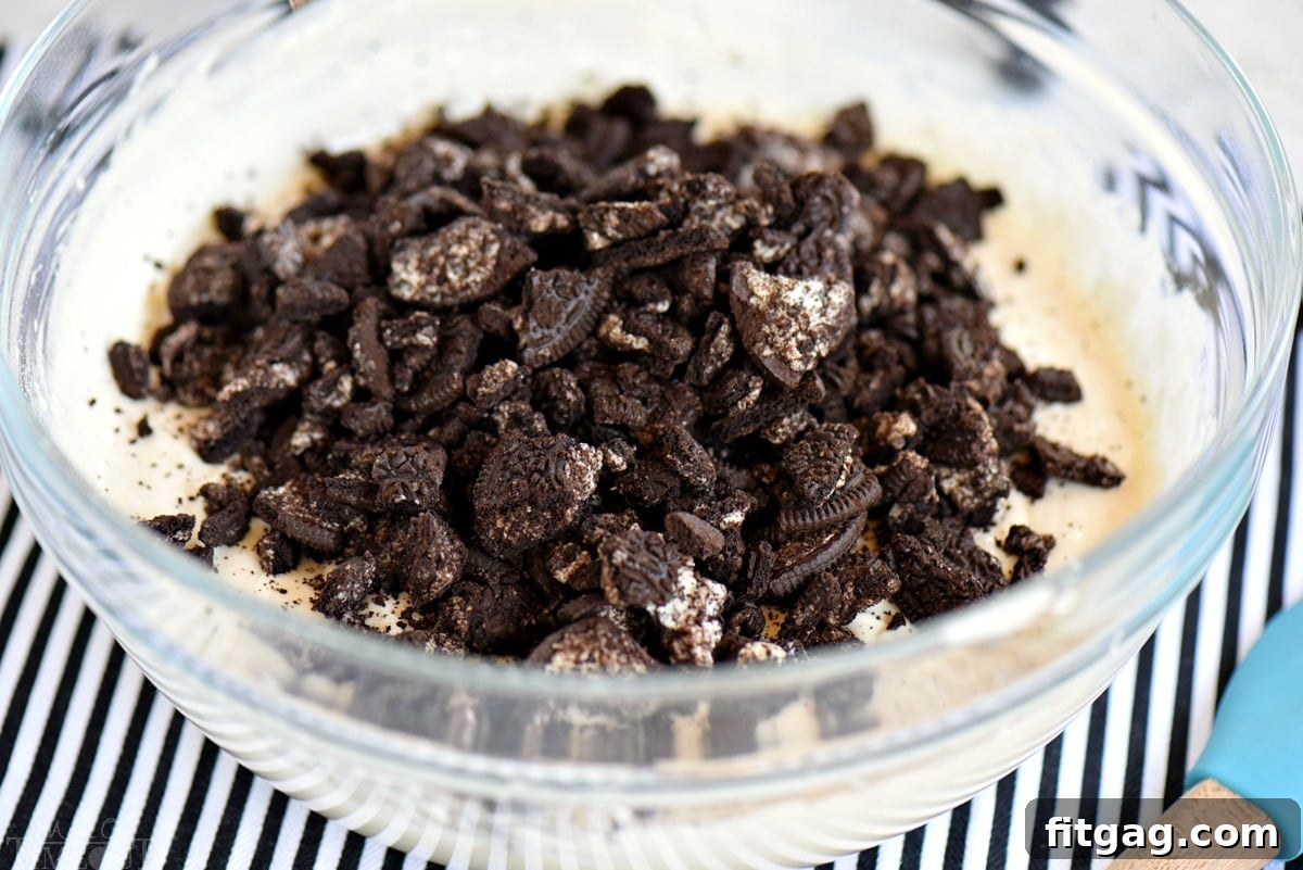 Cookies and cream cake batter with crushed Oreos mixed in, showcasing the perfect consistency before baking.