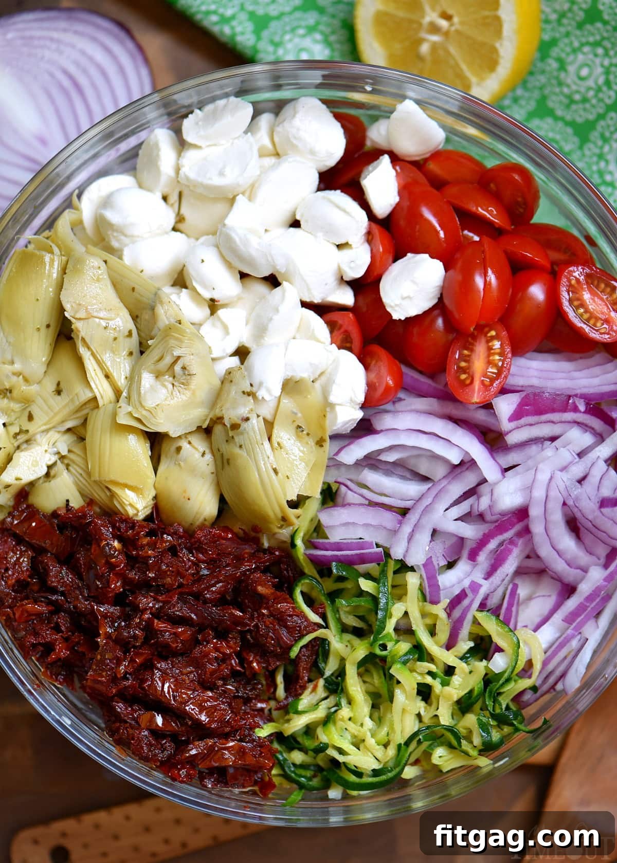 Ingredients for Zucchini Pasta Salad with fresh mozzarella, sun-dried tomatoes, and zucchini spirals.