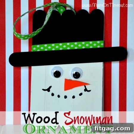 Close-up of a wood snowman ornament with a red and white striped ribbon