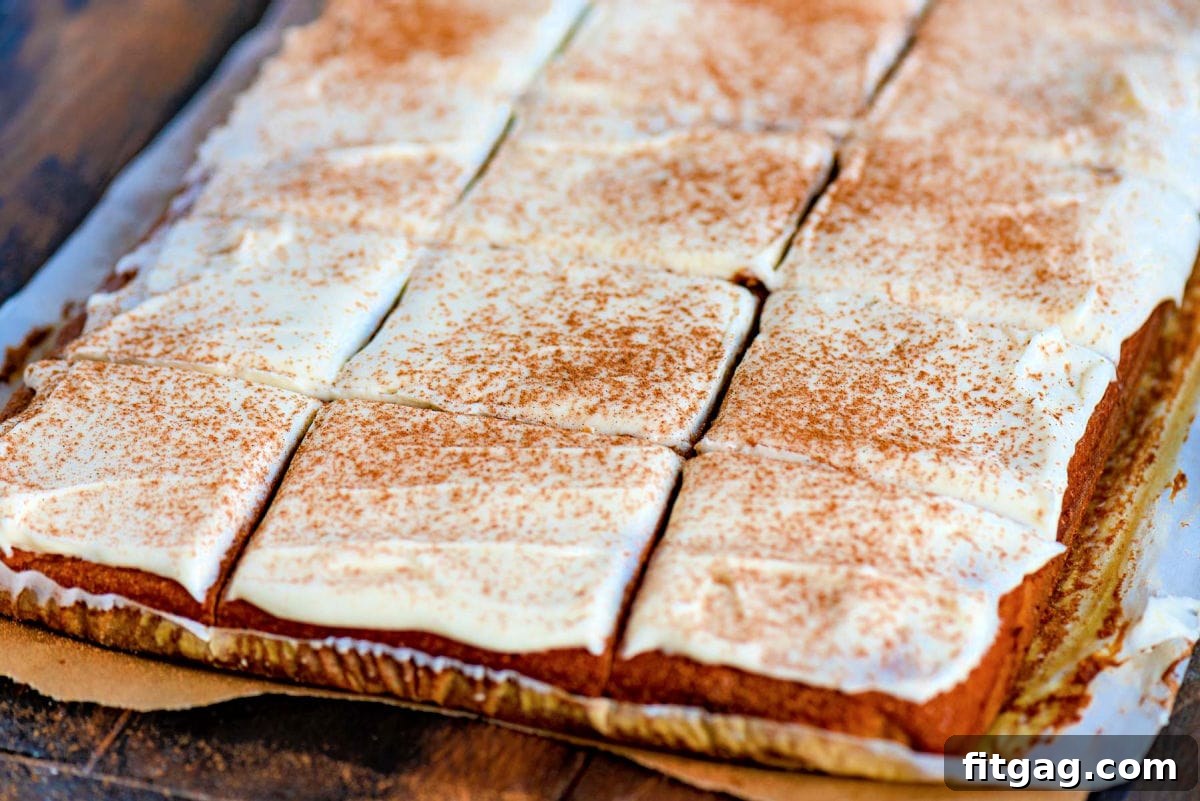 Dreamy Spiced Pumpkin Bars 4 Close-up of frosted pumpkin bars, cut into neat squares and sprinkled with pumpkin pie spice, ready for serving.