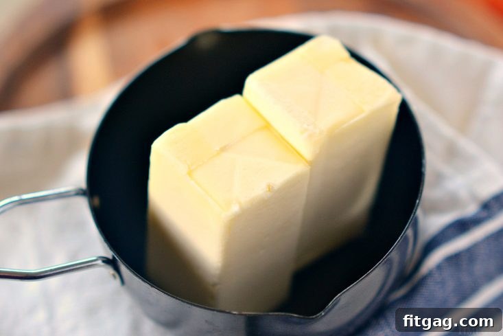 Unsalted butter melting in a small saucepan over low heat, showing initial separation.