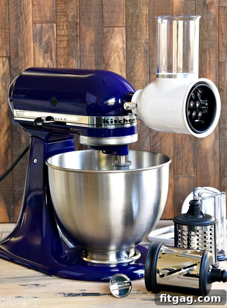 A KitchenAid Deluxe Stand Mixer in cobalt blue on a kitchen counter.