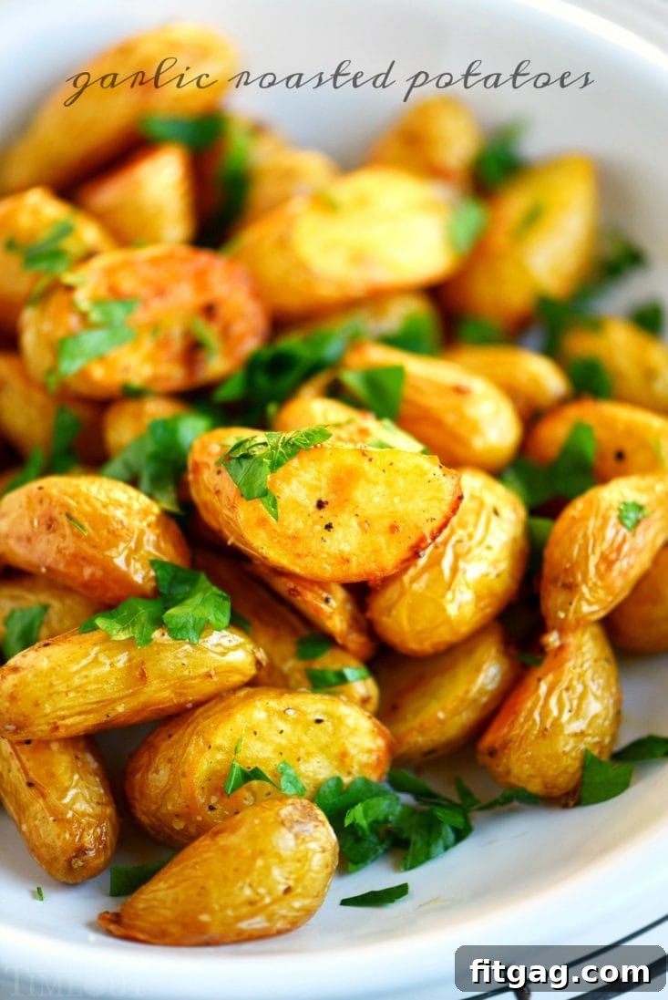 Crispy Garlic Roasted Potatoes on a baking sheet, golden brown and garnished with fresh parsley.