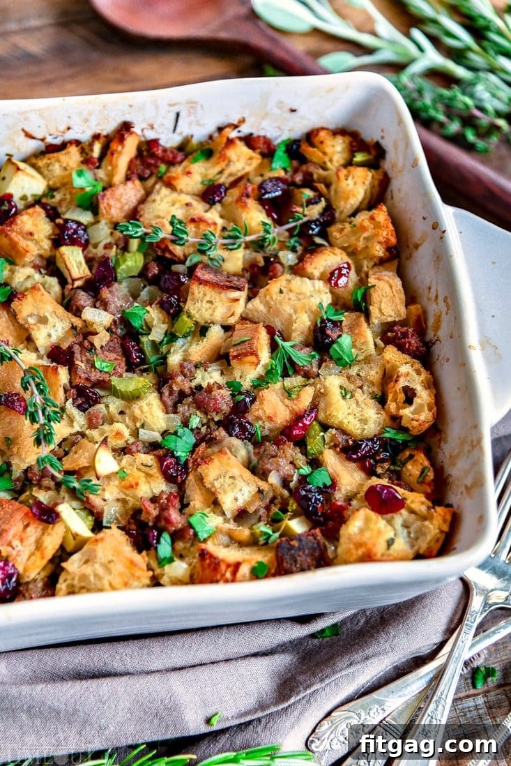 Sweet and Savory Cranberry Apple Sausage Stuffing 7 A close-up of the fully baked Sausage Stuffing, garnished with fresh herbs, ready for serving.