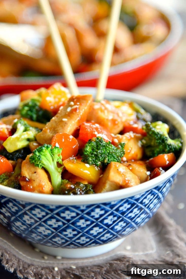 Close-up of a chicken stir fry in a skillet, showcasing golden-brown chicken pieces and crisp, colorful vegetables like broccoli, carrots, and bell peppers.