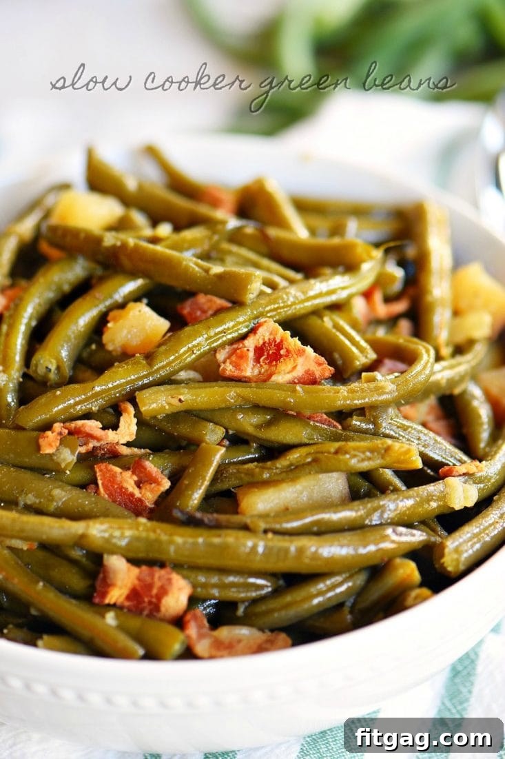 Delicious slow cooker green beans with bacon, potatoes, and onions, cooked to perfection in a crockpot, making an easy and flavorful side dish.