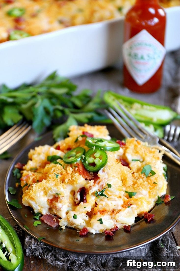 The BEST Jalapeño Popper Mac and Cheese you'll ever try! Extra creamy, loaded with bacon, cream cheese, jalapeños, this delicious and easy mac and cheese is sure to be a new favorite! // Mom On Timeout #macandcheese #dinner #bacon #jalapeno #recipe #recipes #cheese #momontimeout jalapeno-popper-mac-and-cheese-tabasco