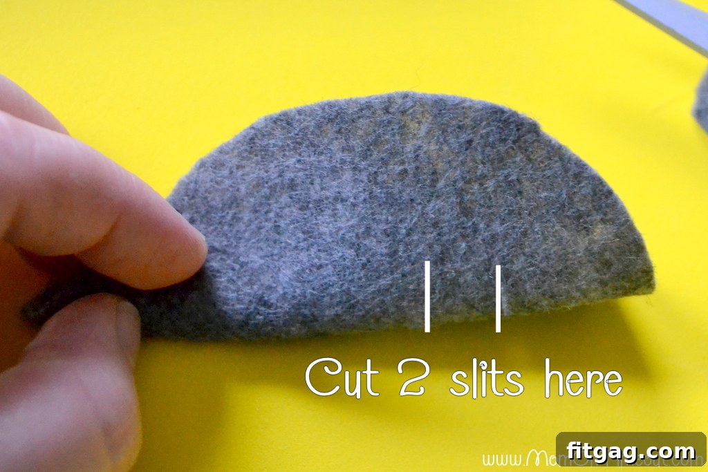 Close-up showing the body of the felt mouse folded in half with two parallel slits cut into it.