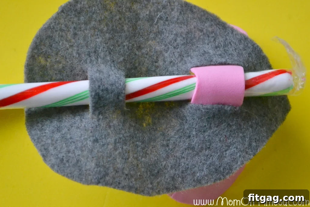 Underside view of the Candy Cane Christmas Mouse, showing how the candy cane threads through both sets of slits for security.