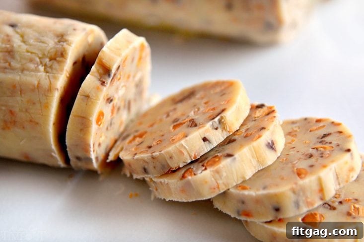 Slices of unbaked butterscotch shortbread cookie dough on a cutting board, ready for baking.