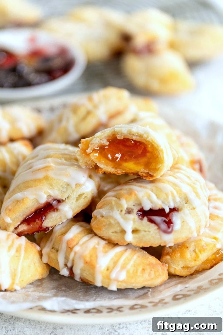 Close-up of golden brown cookie empanadas filled with apricot and raspberry jam.