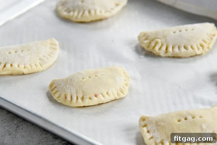 Ready to Bake Cookie Empanadas Unbaked cookie empanadas arranged on a baking sheet before going into the oven.