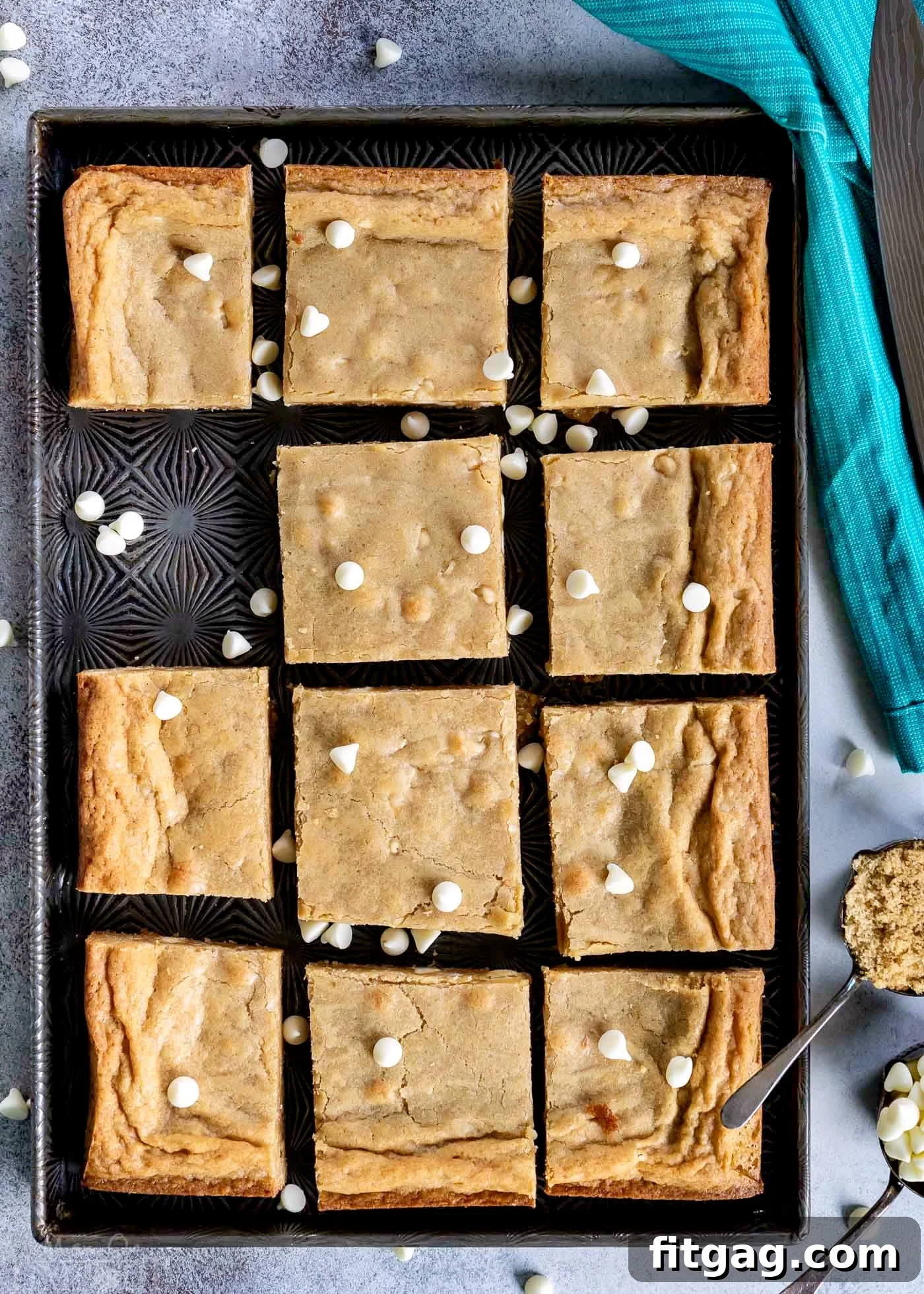 The Best Blondies I've ever had! This easy, one-bowl blondie recipe yields extra chewy, buttery, rich, blondies with hardly any effort at all! top down view of blondies cut into squares and sitting on vintage sheet pan.