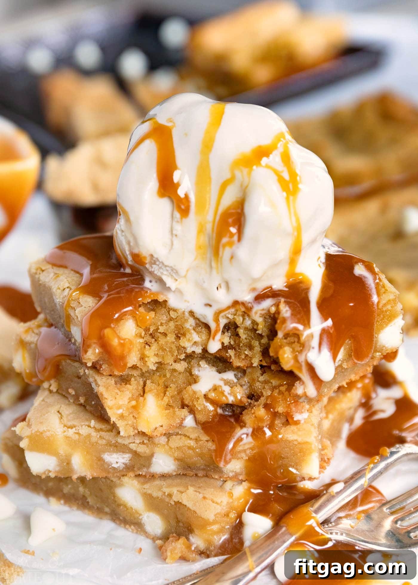 The Best Blondies I've ever had! This easy, one-bowl blondie recipe yields extra chewy, buttery, rich, blondies with hardly any effort at all! // Mom On Timeout #blondies #brownies #bars #dessert #desserts #cookies #cookie #recipe #recipes #baking #easy A decadent stack of four blondies, generously topped with a scoop of creamy vanilla ice cream and drizzled with luscious caramel sauce, promising an irresistible dessert experience.