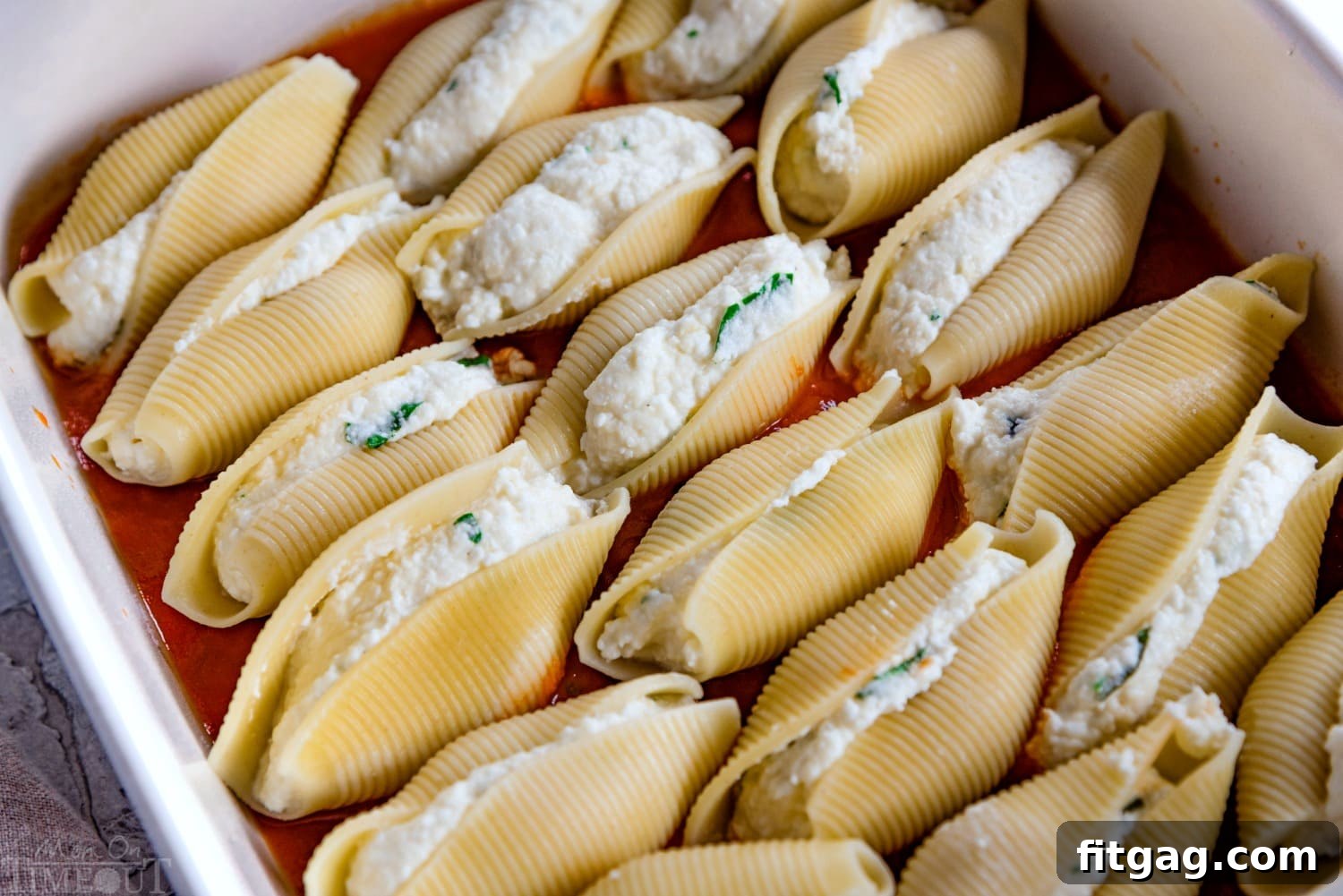 Shells Stuffed and Sauced Stuffed shells arranged in marinara sauce in a baking dish, ready for the oven.