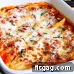 Baked stuffed shells topped with fresh basil and melted cheese ready to be served.