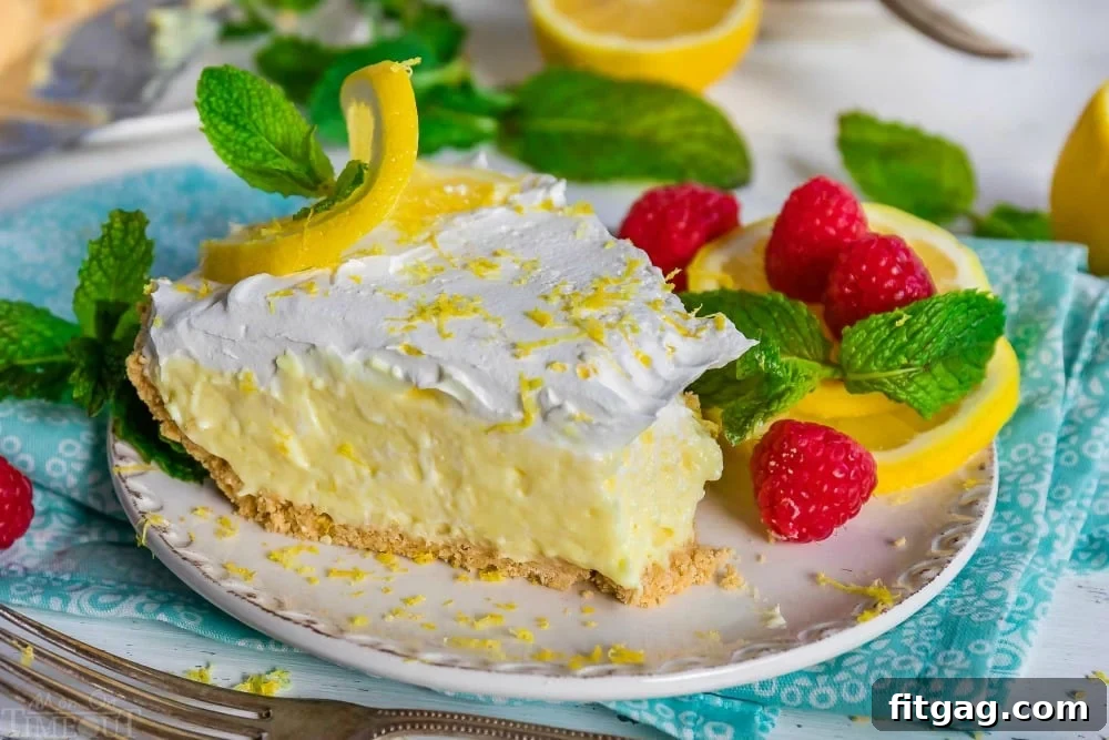 A slice of No-Bake Lemon Pie on a white plate with a bite taken out
