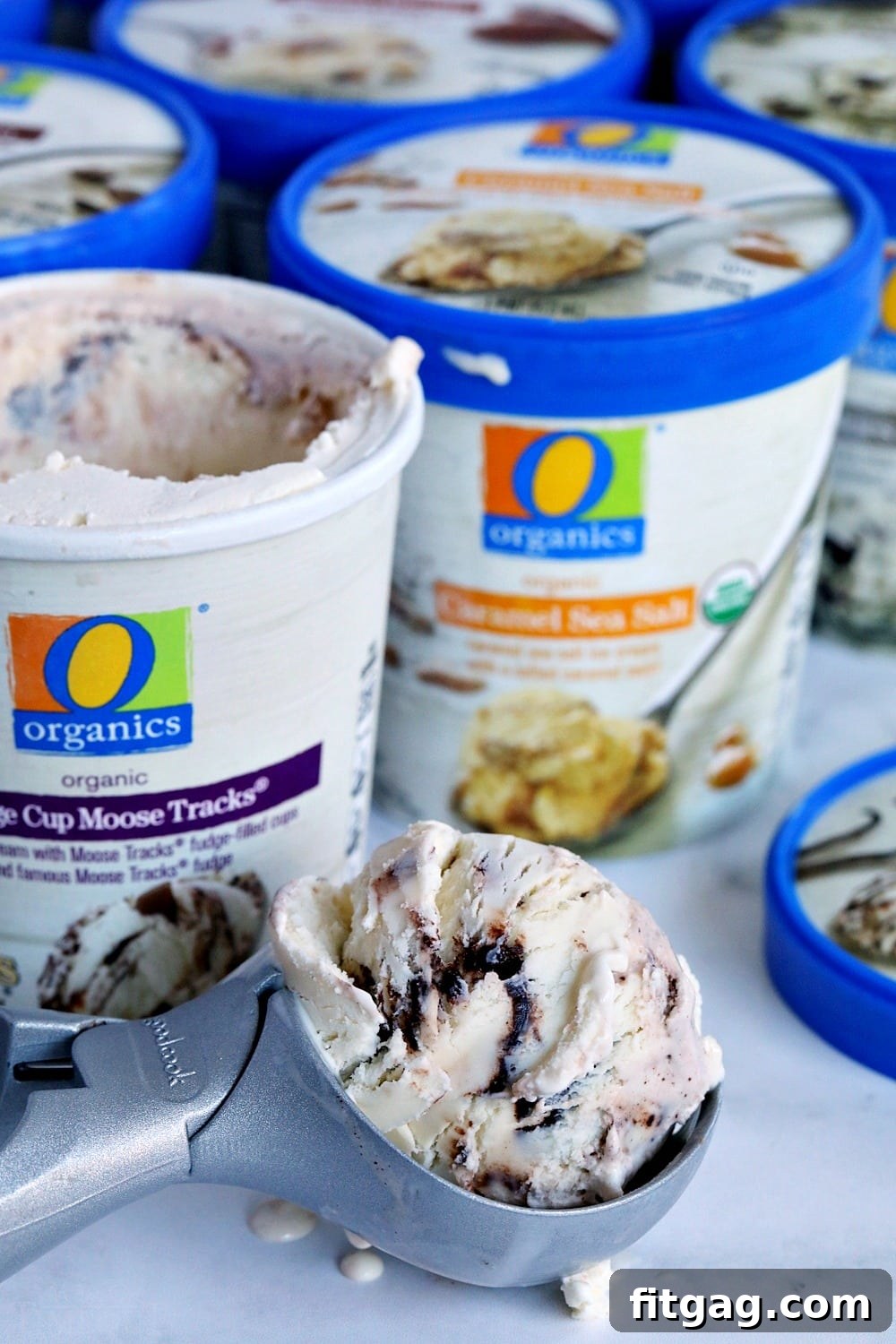 Close-up of a hand holding a delicious O Organics ice cream pint, highlighting the quality and organic nature of the product, ready for making ice cream sandwiches.