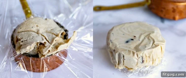 Ice cream being scooped into a measuring cup lined with plastic wrap, demonstrating a method for creating perfect ice cream discs for sandwiches.