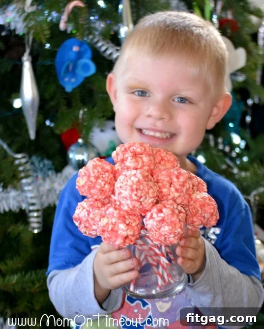 Excited child holding a Marshmallow Peppermint Crunch Popcorn Ball Pop
