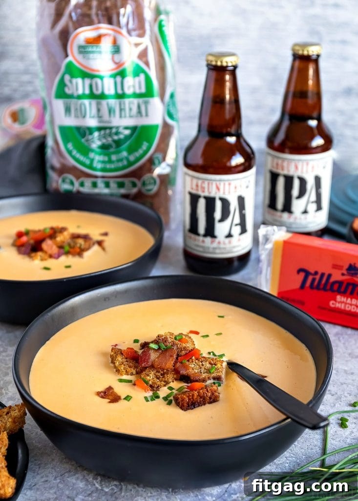 Close-up of a bowl of Beer Cheese Soup, richly textured, topped with crumbled bacon and crispy croutons.