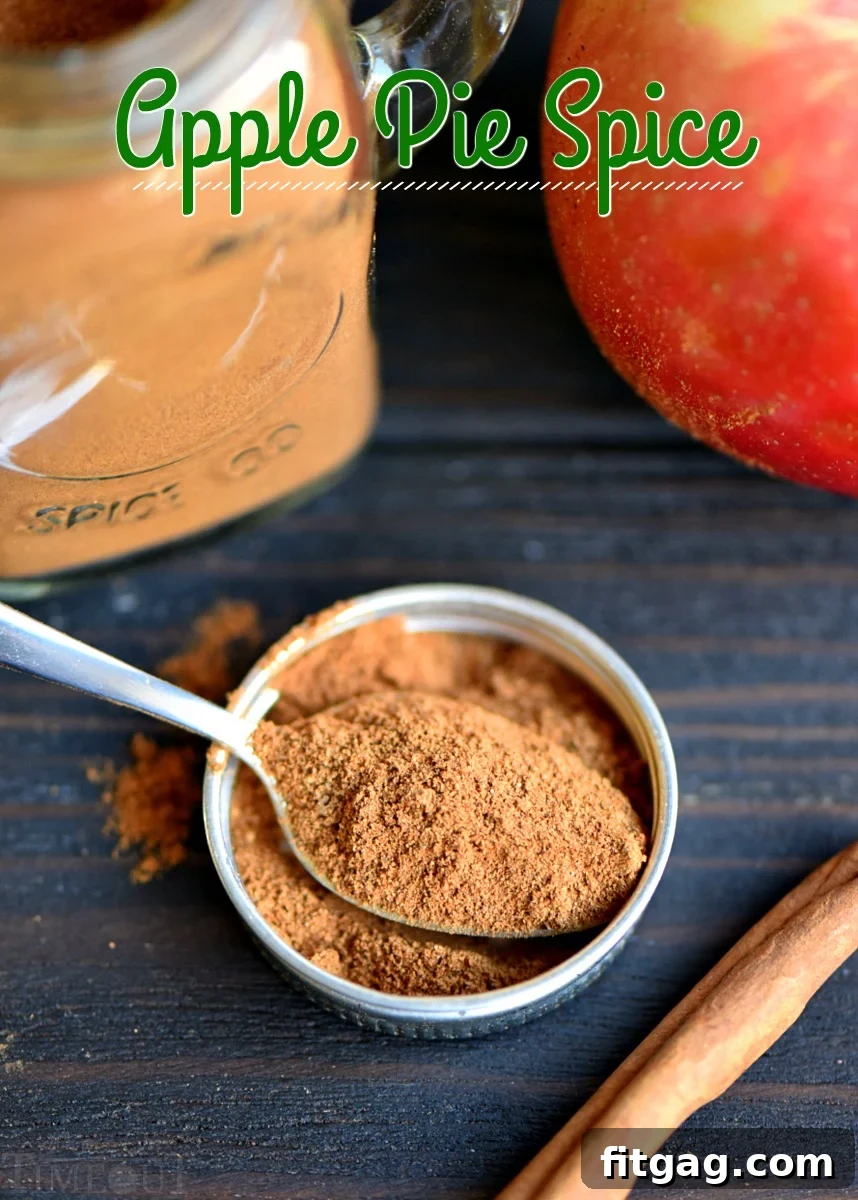 Essential Homemade Apple Pie Spice for Fall Baking A close-up shot of a spoon brimming with rich brown homemade apple pie spice mix, poised over a small bowl, ready to be incorporated into delicious fall recipes.