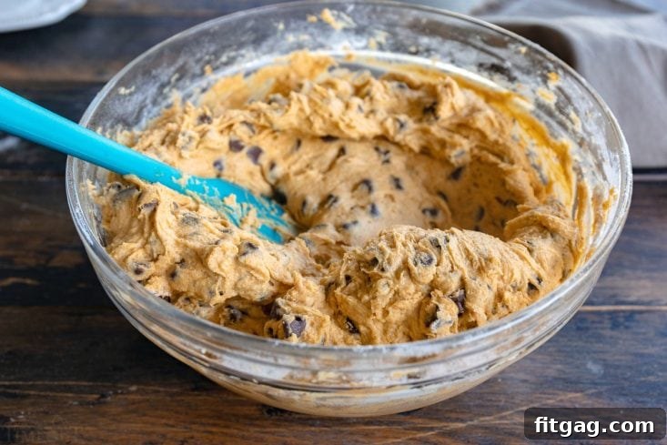 Pumpkin cake batter in a mixing bowl with chocolate chips